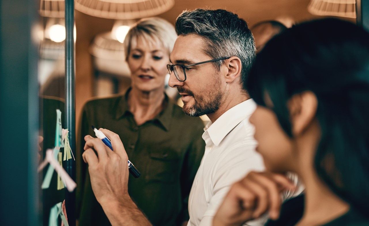 Colleagues discussing application modernization on a whiteboard
