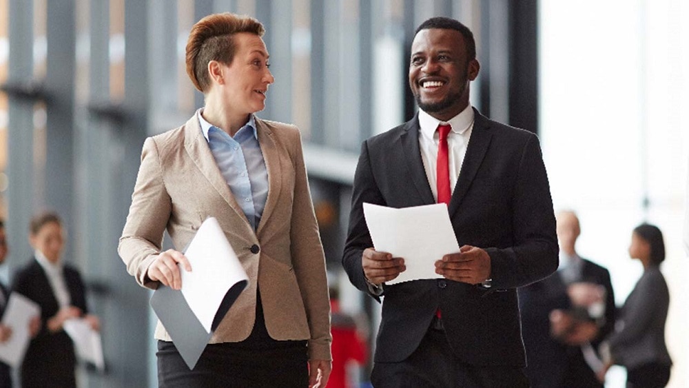 Two colleagues smiling while walking