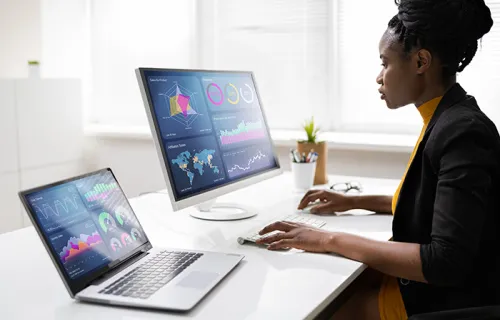 person analyzing data on two monitors