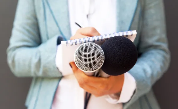 Analyst holding microphones and notepad