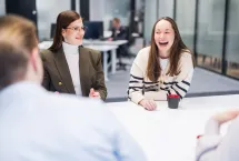 Kuvassa CGI:n konsultit viettävät aikaa yhdessä toimistolla ja nauravat