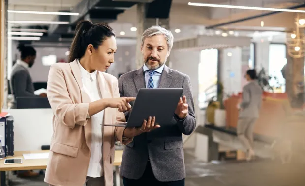 Executives discussing CGI DigiOps on a laptop