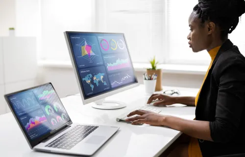 professional analyzing data on two screens