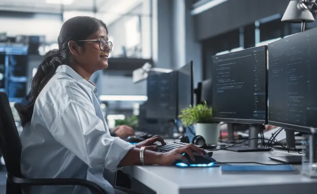Woman working on multiple screens