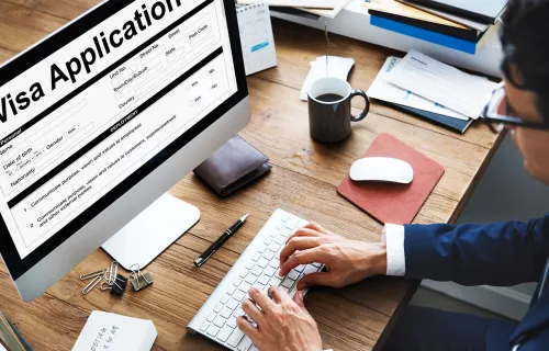 Person completing a visa application on a computer