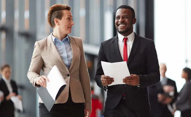 Two colleagues smiling while walking